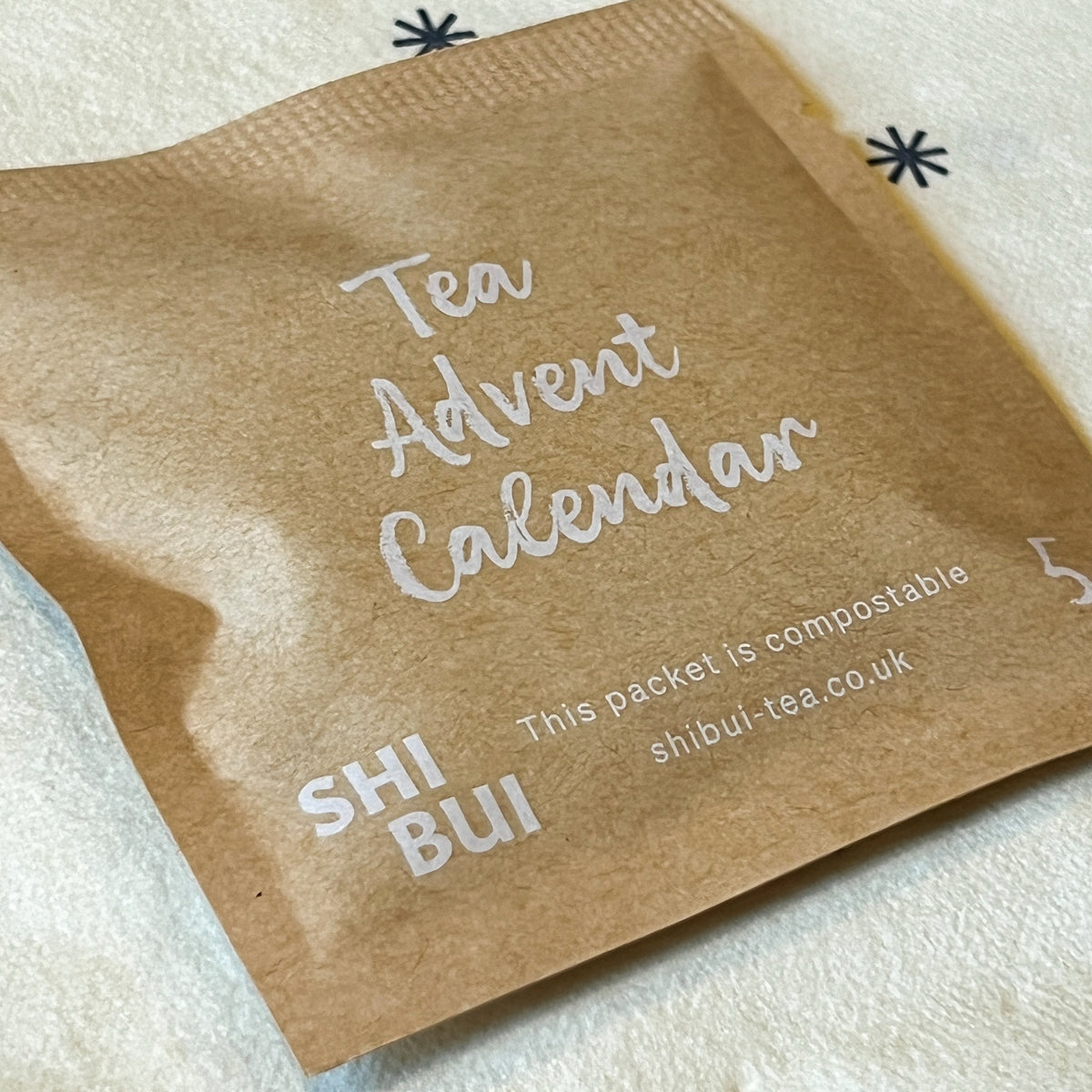 Close-up of a Shibui Tea Advent Calendar paper sachet showing the compostable packaging